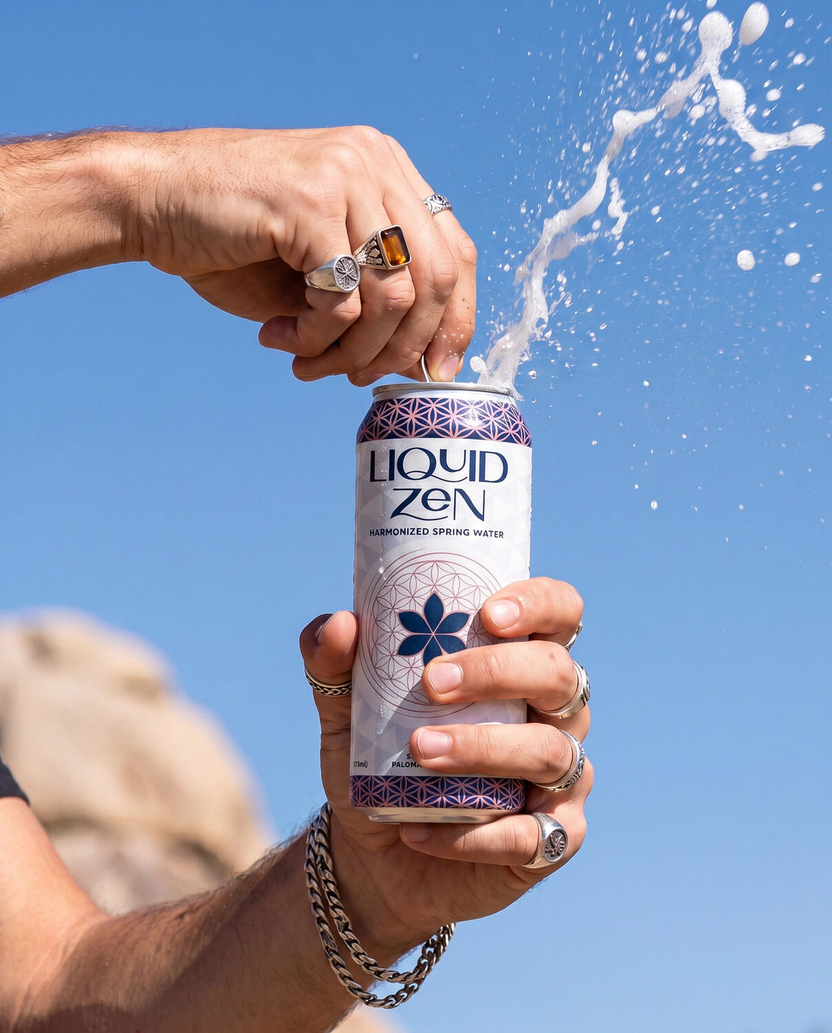 Cracking open a can of Liquid Zen against a clear blue sky